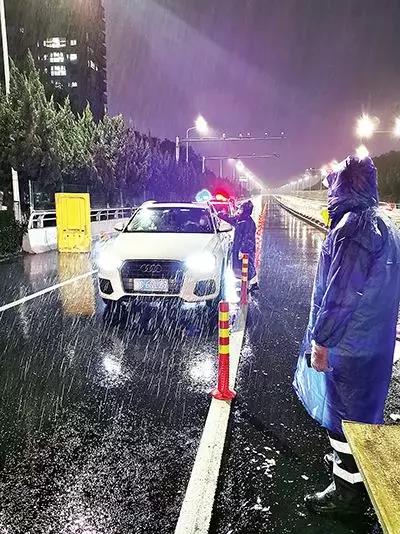 凌晨，東甌大橋卡點處，永嘉縣黨員干部頂風(fēng)冒雨、在嚴(yán)寒中牢牢值守。（　圖片由浙江省溫州市委組織部提供）